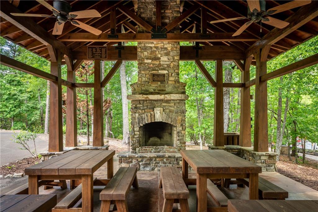 206 R Mystic Trail Lane Jasper, GA 30143 - Photo 31 of 38 a view of a patio with table and chairs a barbeque with wooden floor and roof with a garden view