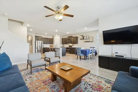 a living room with furniture kitchen view and a flat screen tv