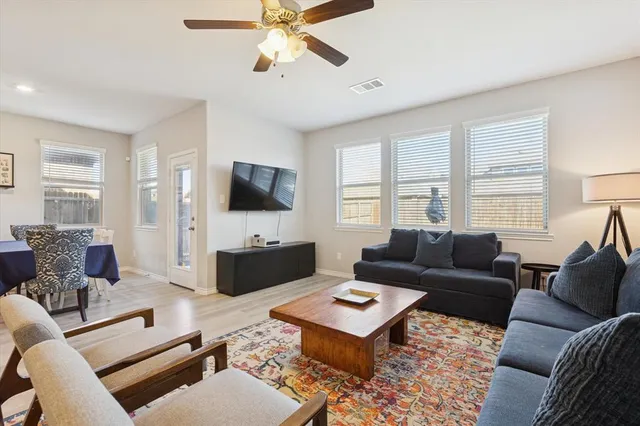 a living room with furniture a flat screen tv and a window