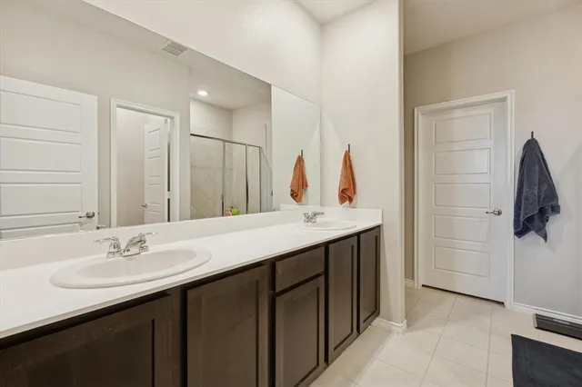 a bathroom with a double vanity sink a mirror and shower