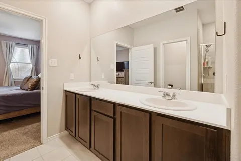 a en suite bathroom with a double vanity sink and a mirror