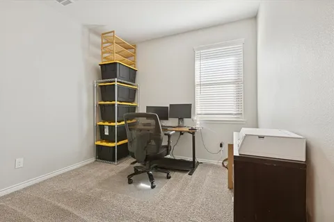 a view of a workspace with furniture and a window