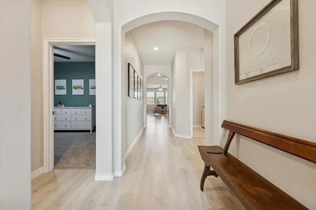 a view of a hallway with wooden floor and a bathroom