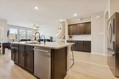 a kitchen with stainless steel appliances granite countertop a sink a stove and a refrigerator