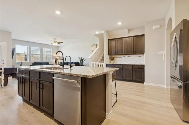 a kitchen with stainless steel appliances granite countertop a sink a stove and a refrigerator