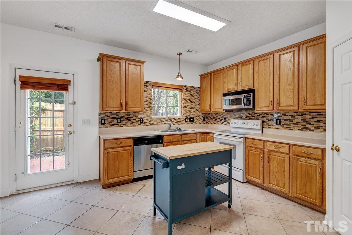 3367 Bridgeville Road Raleigh, NC 27610 - Photo 11 of 34 a kitchen with stainless steel appliances granite countertop a stove a sink dishwasher a refrigerator and a microwave oven with white cabinets