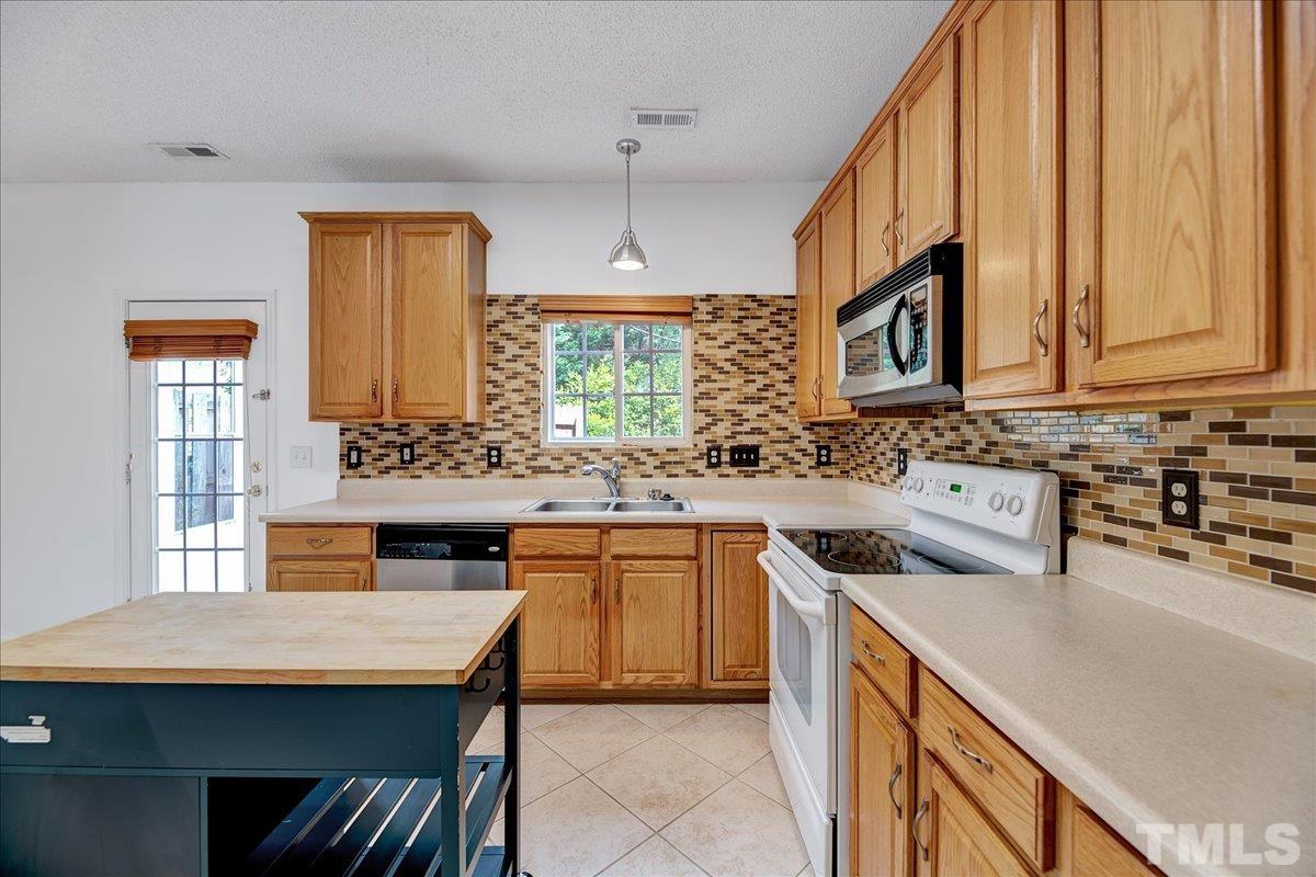 3367 Bridgeville Road Raleigh, NC 27610 - Photo 13 of 34 a kitchen with stainless steel appliances granite countertop a sink stove and refrigerator