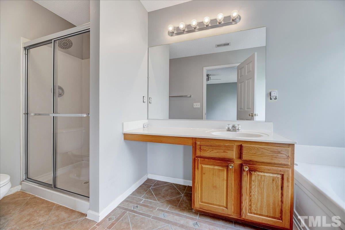 3367 Bridgeville Road Raleigh, NC 27610 - Photo 29 of 34 a bathroom with a sink a mirror and a shower