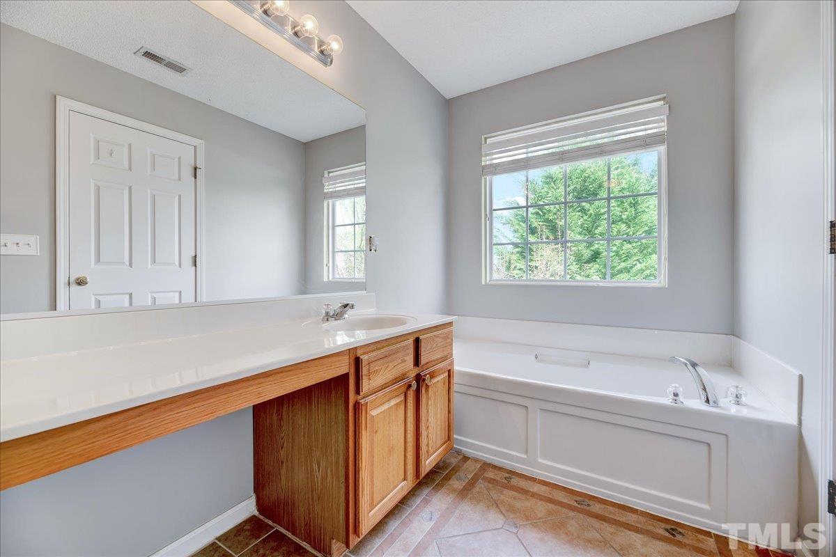 3367 Bridgeville Road Raleigh, NC 27610 - Photo 30 of 34 a bathroom with a tub sink and mirror