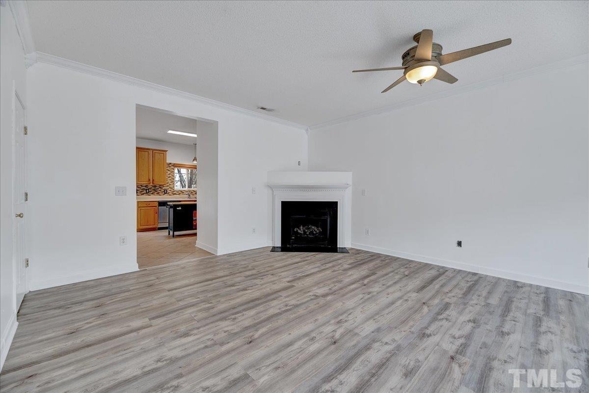 3367 Bridgeville Road Raleigh, NC 27610 - Photo 6 of 34 wooden floor fireplace and windows in an empty room