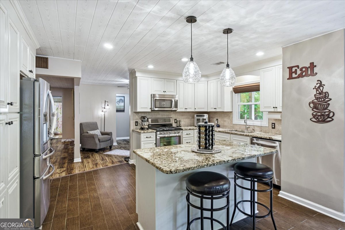 265 Floyd Road Hampton, GA 30228 - Photo 14 of 64 a kitchen with granite countertop a stove a sink a oven a dining table and chairs