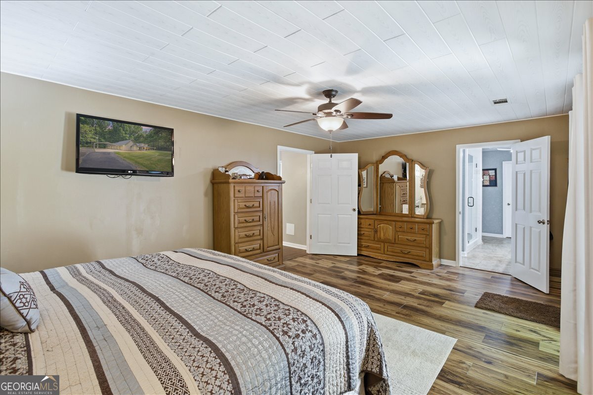 265 Floyd Road Hampton, GA 30228 - Photo 18 of 64 a bedroom with a large bed a chandelier and closet