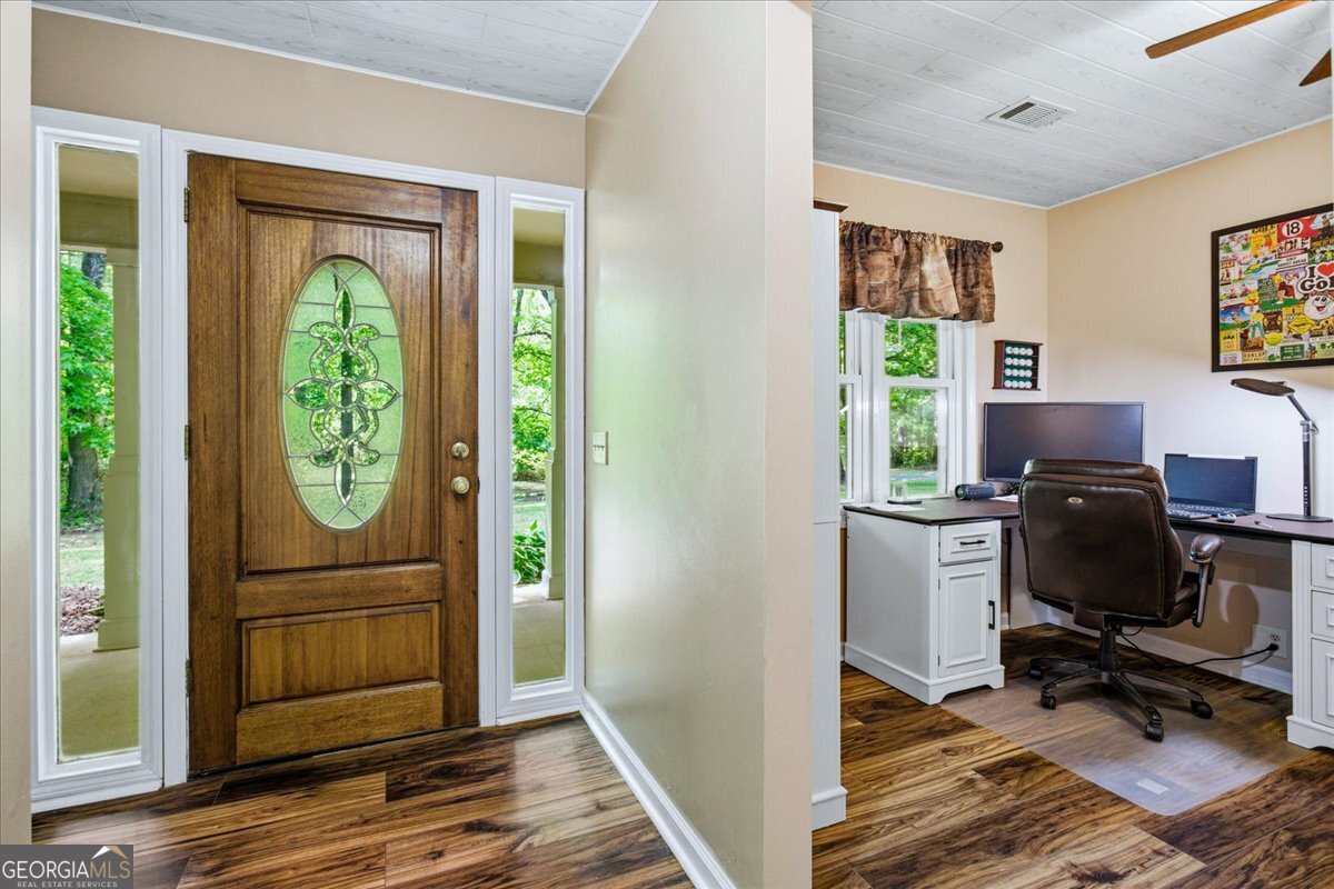 265 Floyd Road Hampton, GA 30228 - Photo 3 of 64 a view of workspace with wooden floor windows cabinet and couch