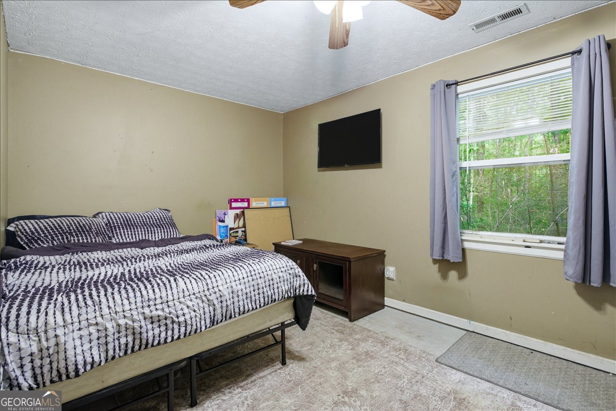 265 Floyd Road Hampton, GA 30228 - Photo 31 of 64 a bedroom with a bed and a tv