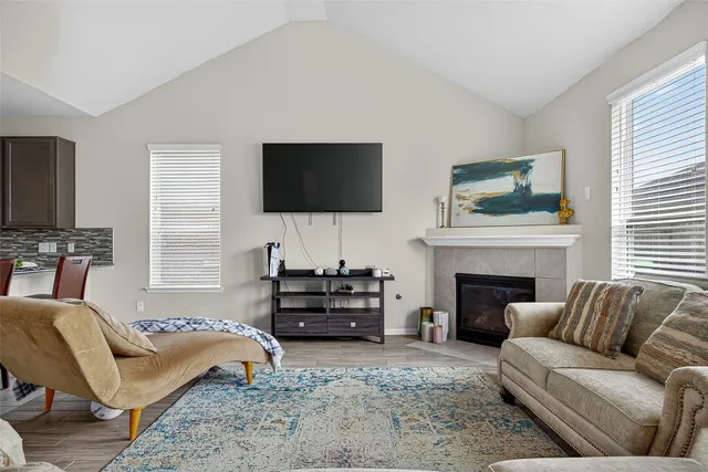 a living room with furniture a fireplace and a flat screen tv