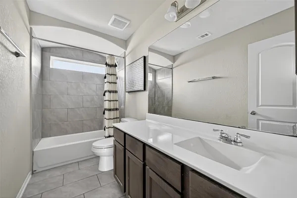 a bathroom with a double vanity sink toilet mirror and shower
