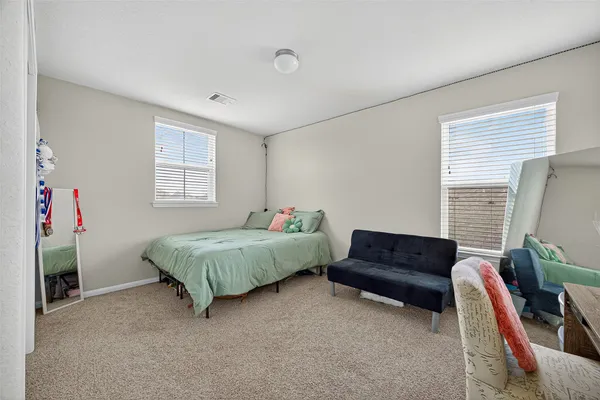 a spacious bedroom with a bed and a couch