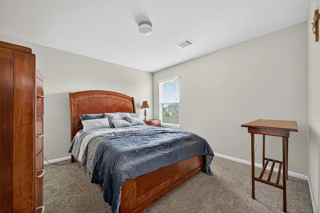 a bedroom with a bed a table and chair