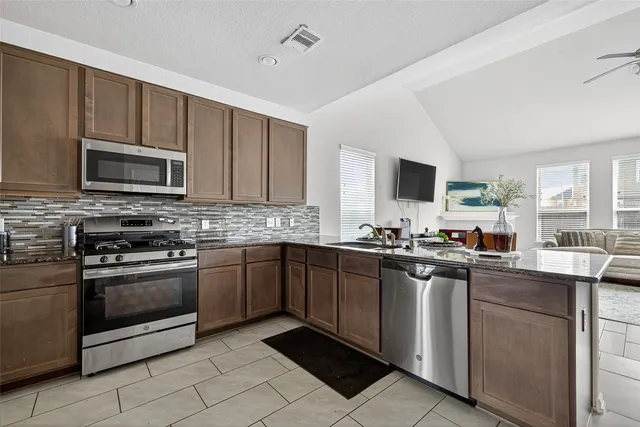 a kitchen with stainless steel appliances granite countertop a stove sink microwave and cabinets