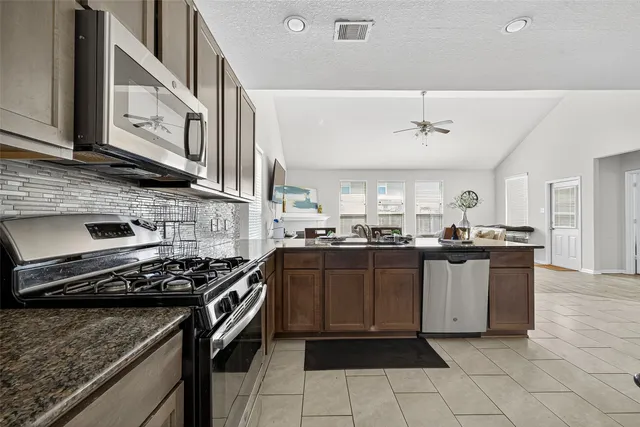 a kitchen with stainless steel appliances granite countertop a stove and a sink