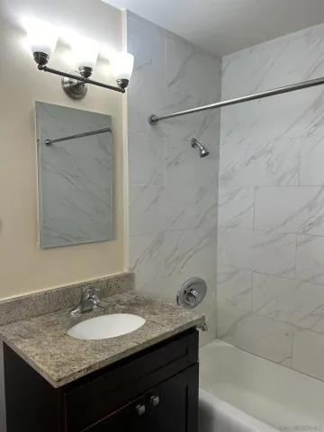 a bathroom with a granite countertop sink and a mirror