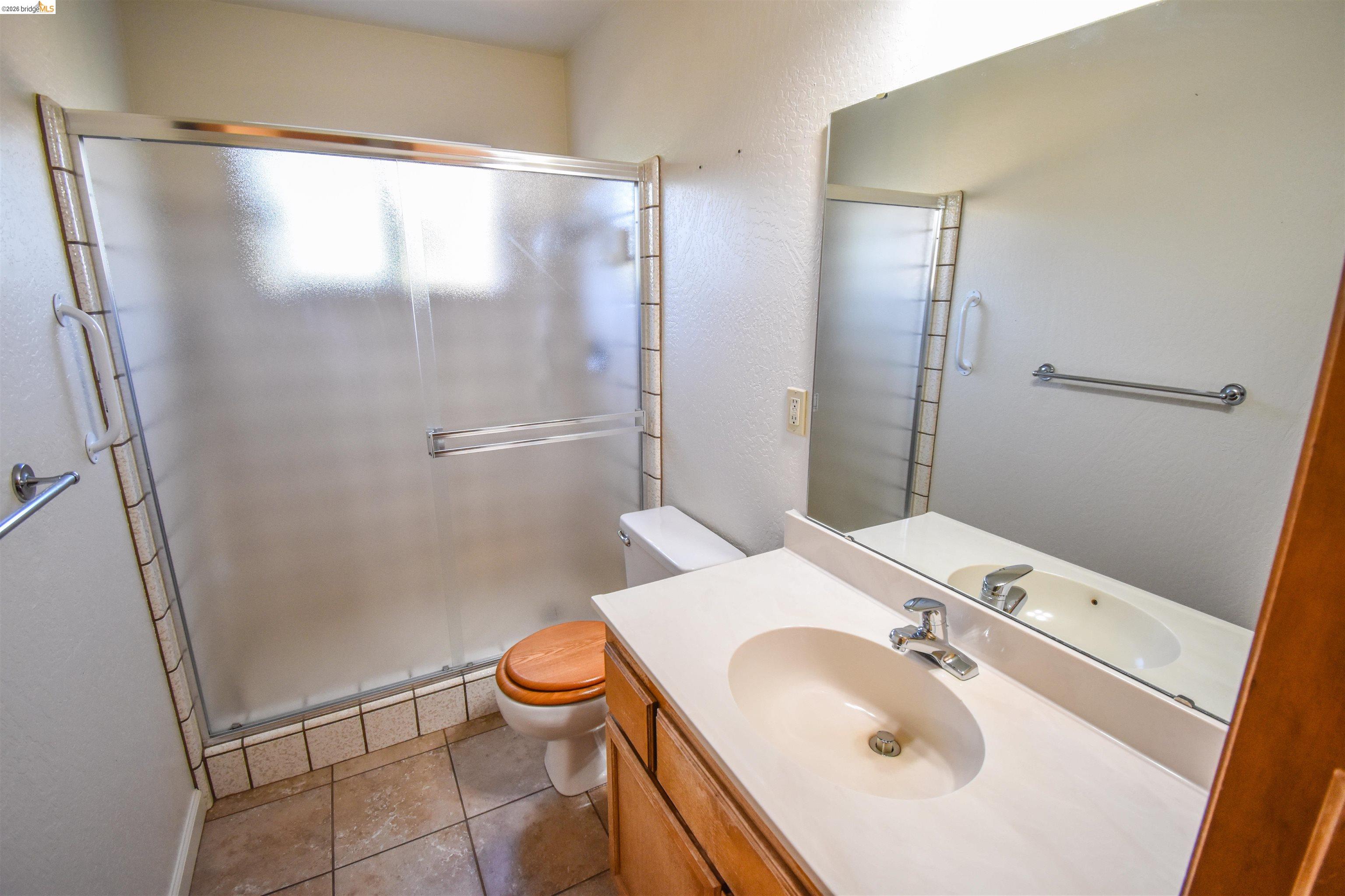 23685 Marble Quarry Road, Unit 22 Columbia, CA 95310 - Photo 15 of 33 Full bath with vanity, a stall shower, light tile patterned floors, and a textured wall