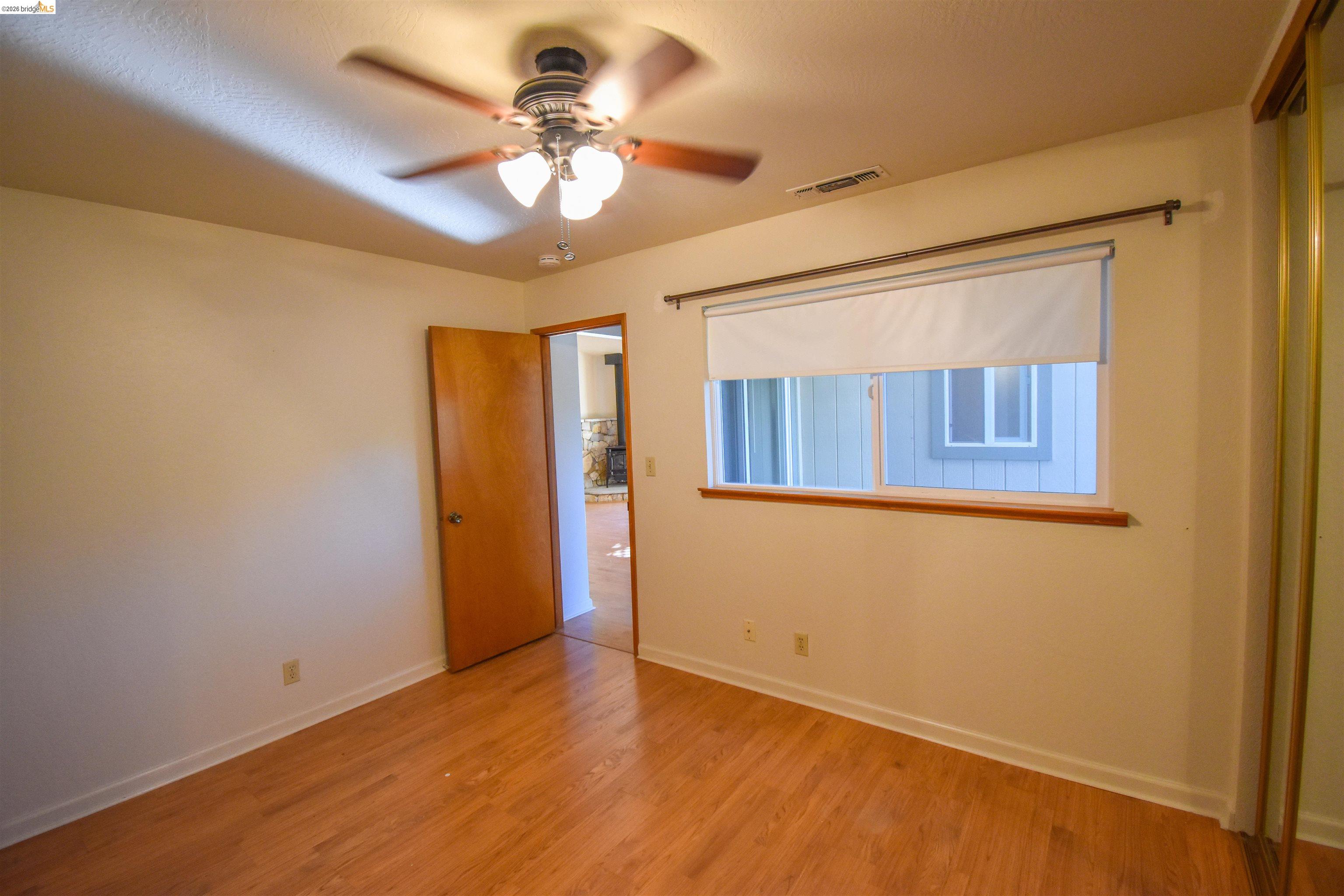 23685 Marble Quarry Road, Unit 22 Columbia, CA 95310 - Photo 18 of 33 Unfurnished bedroom featuring light wood-style floors and a ceiling fan