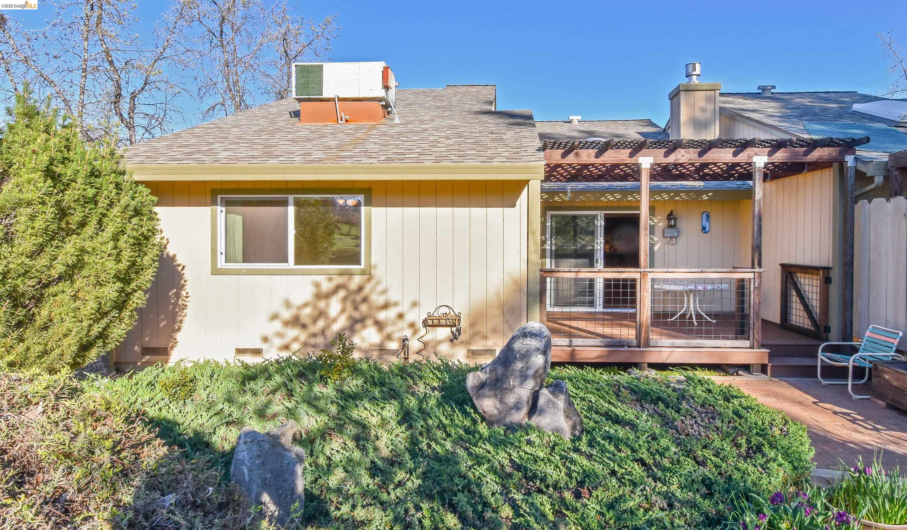23685 Marble Quarry Road, Unit 22 Columbia, CA 95310 - Photo 27 of 33 Back of property featuring a wooden deck, a shingled roof, a chimney, and a pergola
