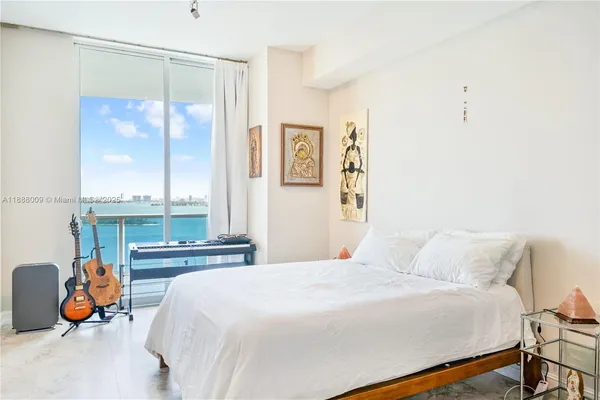 a bedroom with a bed and a large window