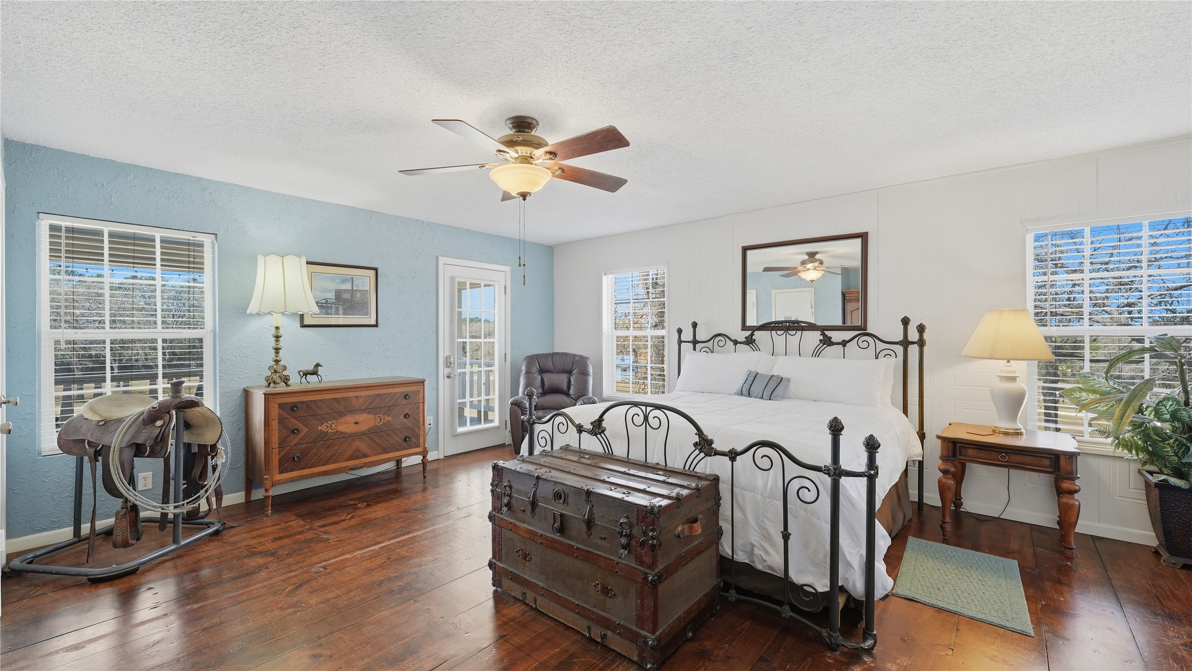 182 Little Ranch Road Red Rock, TX 78662 - Photo 22 of 40 Bedroom featuring access to outside, dark wood-style flooring, a textured ceiling, and a ceiling fan