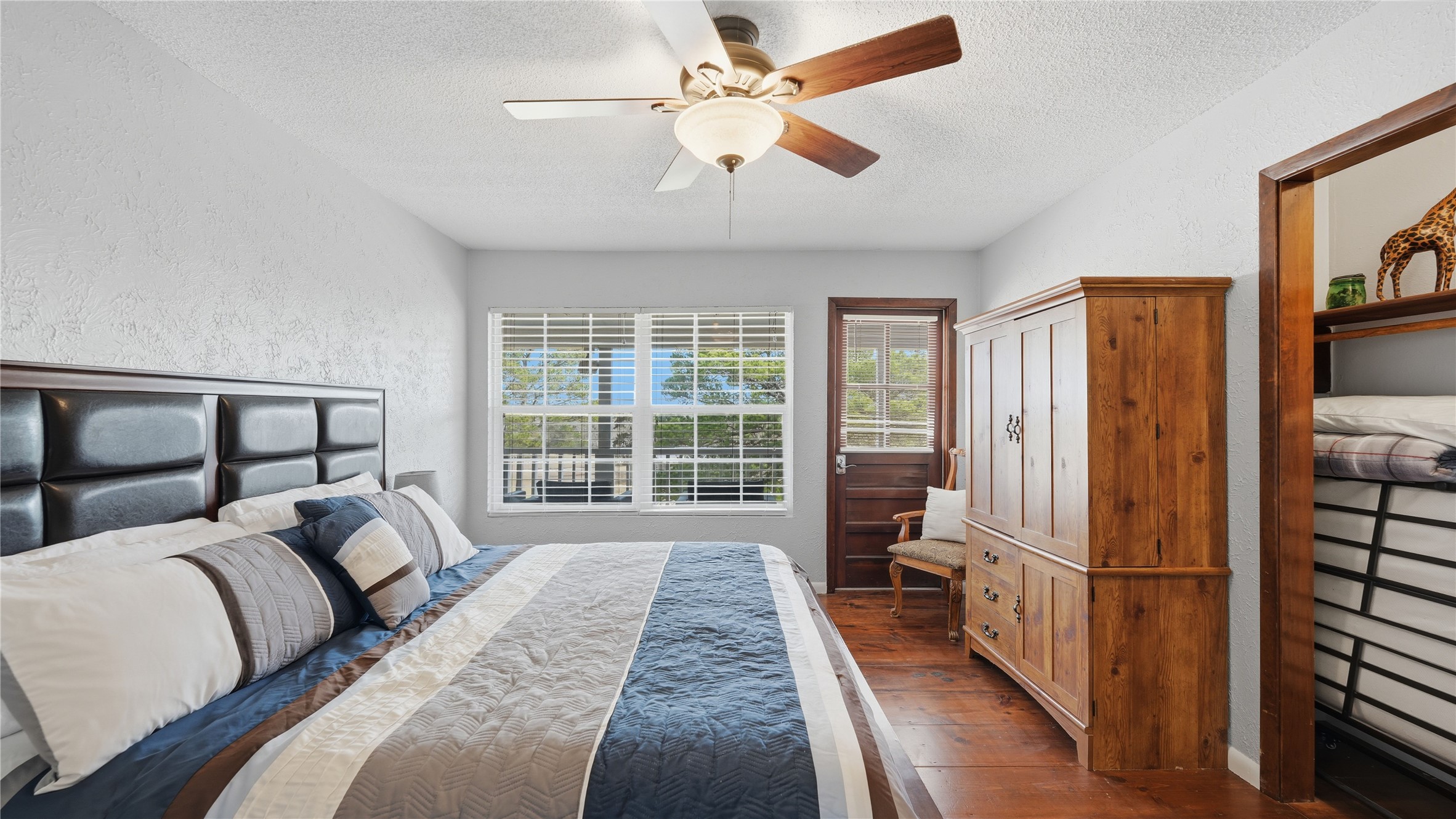 182 Little Ranch Road Red Rock, TX 78662 - Photo 24 of 40 Bedroom with a textured wall, dark wood-type flooring, a ceiling fan, and a textured ceiling