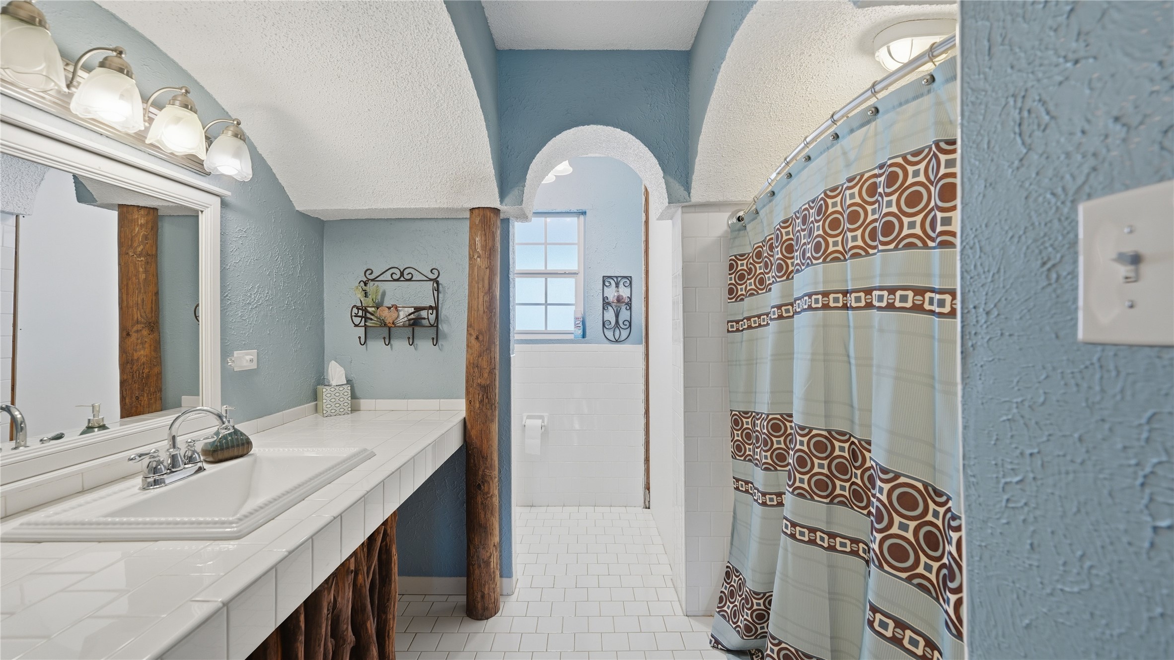 182 Little Ranch Road Red Rock, TX 78662 - Photo 28 of 40 Bathroom with a textured wall, vanity, a shower with shower curtain, and light tile patterned flooring