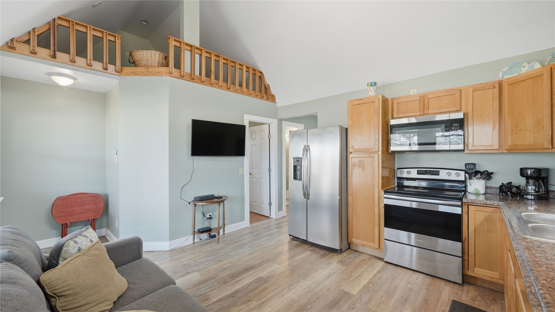 182 Little Ranch Road Red Rock, TX 78662 - Photo 40 of 40 Kitchen with stainless steel appliances, light wood finished floors, light wood finish cabinets, lofted ceiling, and open floor plan
