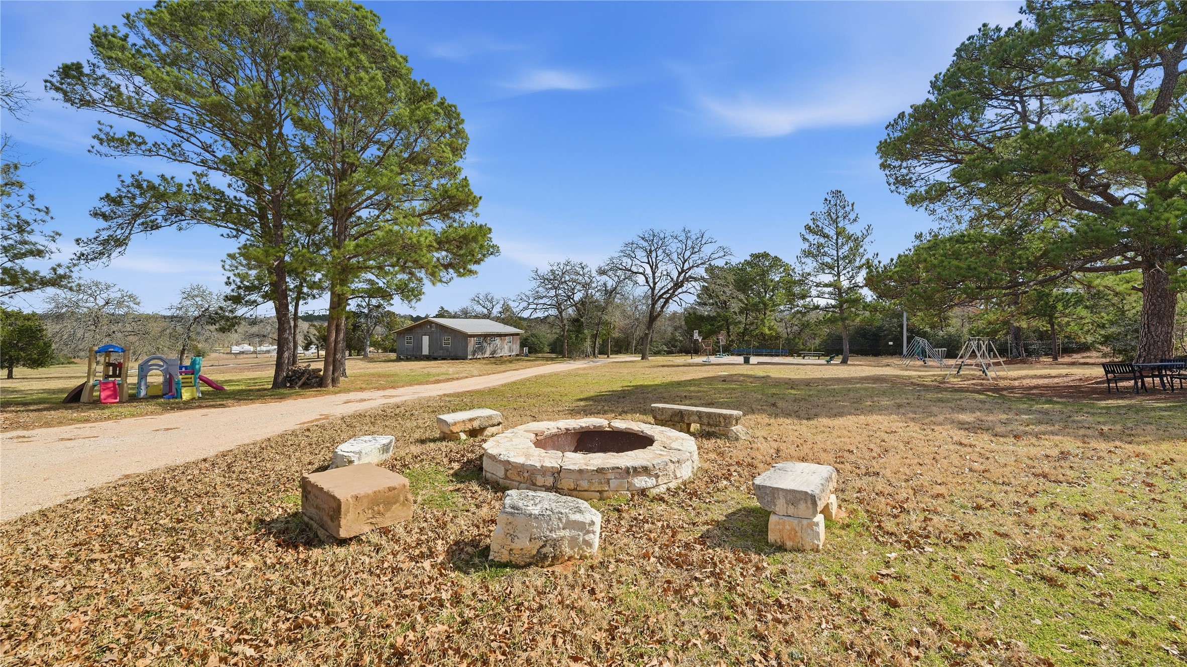 182 Little Ranch Road Red Rock, TX 78662 - Photo 8 of 40 View of green lawn featuring a playground and a fire pit