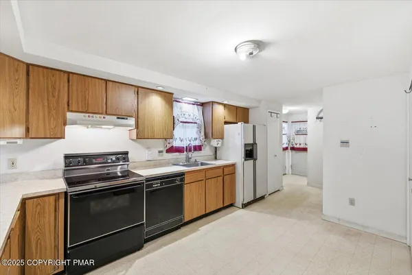 a kitchen with stainless steel appliances a stove a sink and a refrigerator