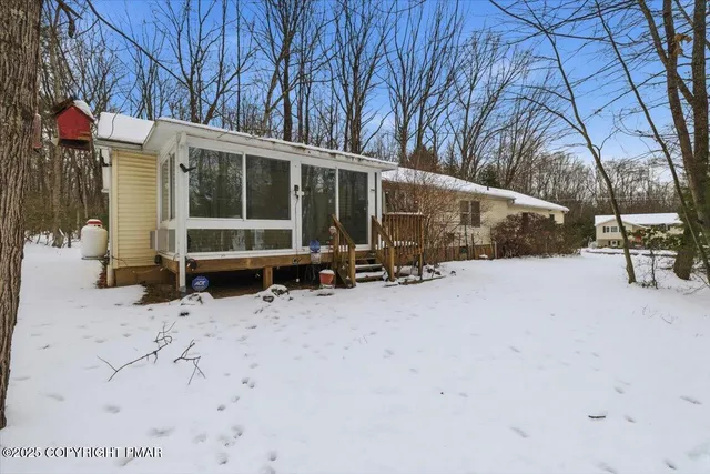 a view of a house with a yard covered in snow