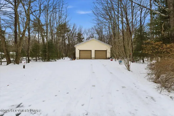 a front view of a house with a yard covered in snow