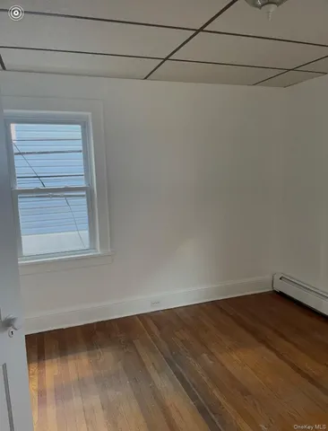 a view of a small space with wooden floor and a window