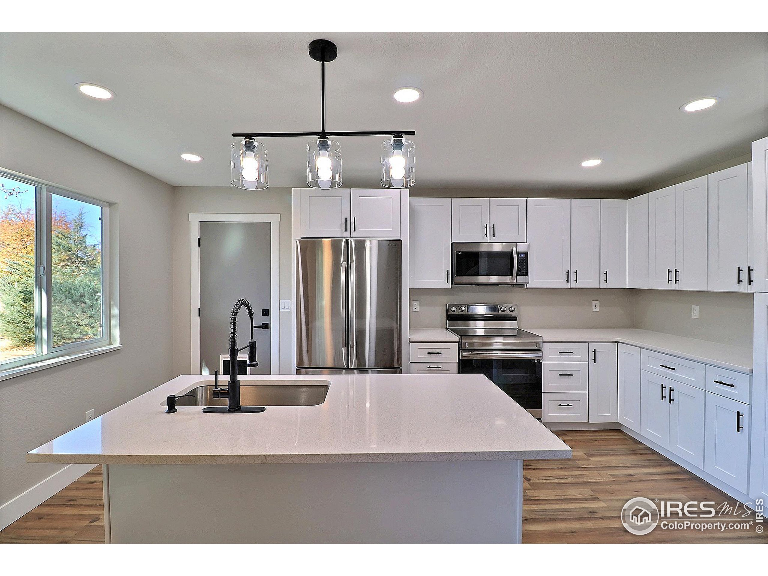 a kitchen with kitchen island a sink stainless steel appliances and window