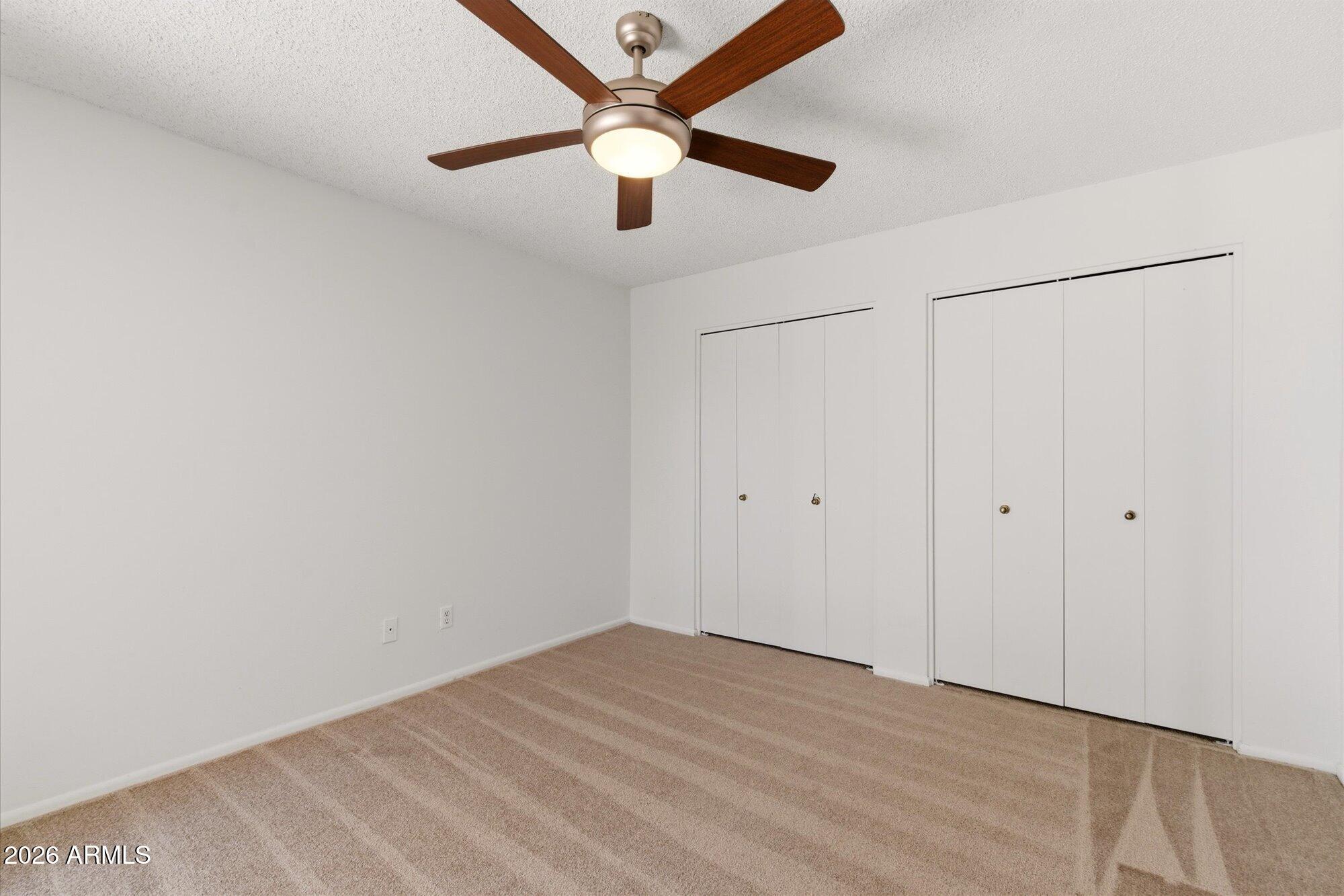 4208 East Carson Road Phoenix, AZ 85042 - Photo 13 of 25 an empty room with a ceiling fan and a window