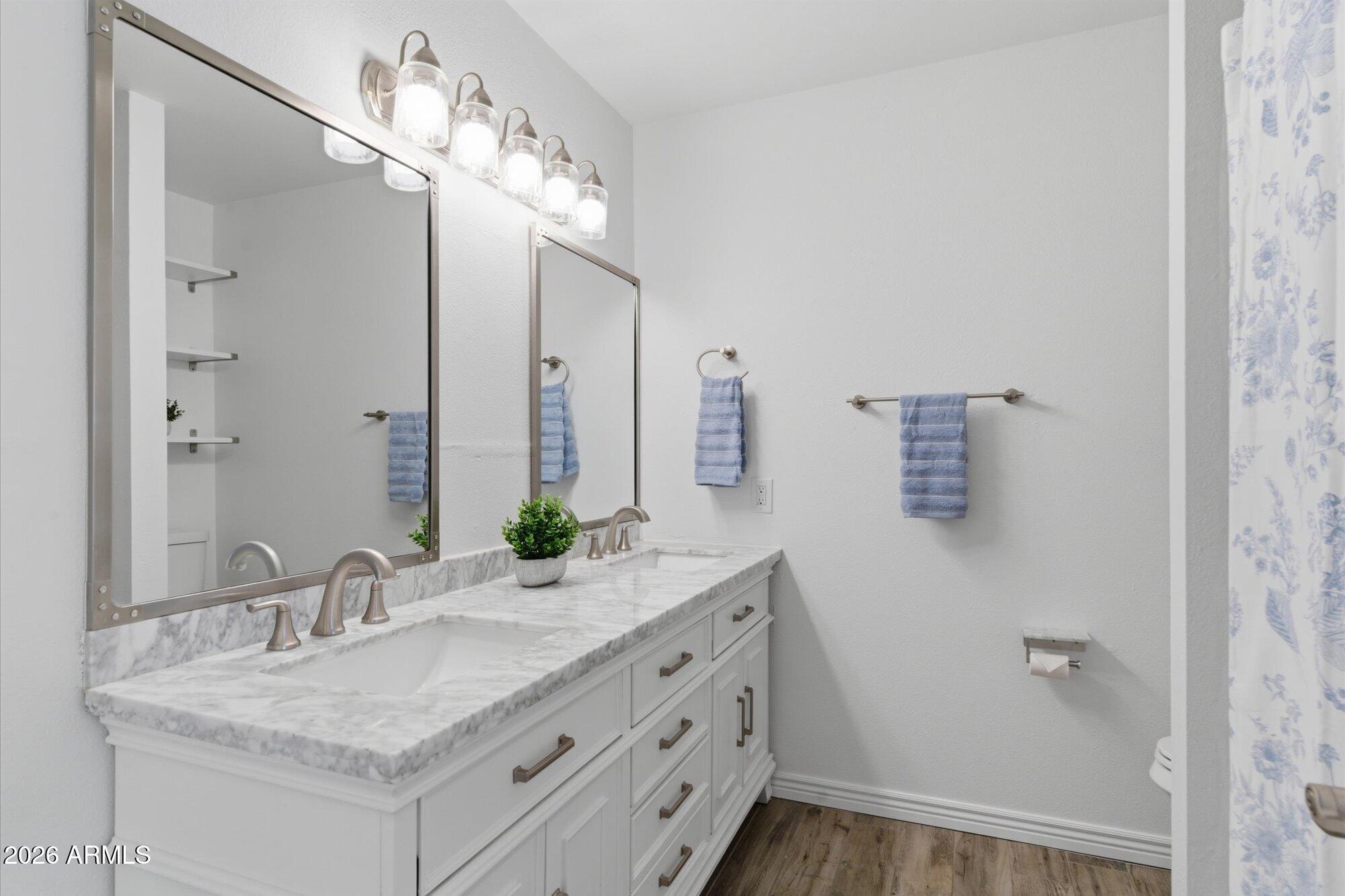 4208 East Carson Road Phoenix, AZ 85042 - Photo 17 of 25 a bathroom with a granite countertop sink a mirror and a shower