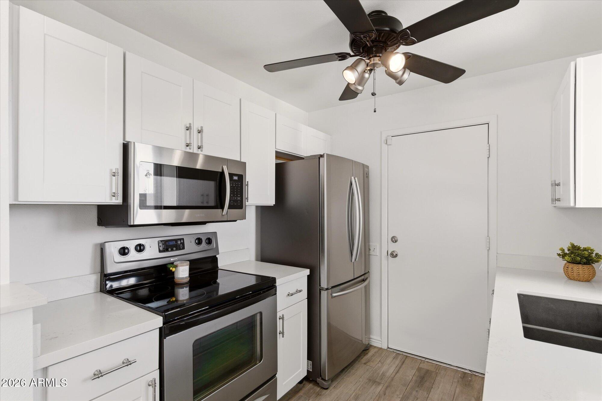 4208 East Carson Road Phoenix, AZ 85042 - Photo 10 of 25 a kitchen with stainless steel appliances a refrigerator a stove a microwave and cabinets