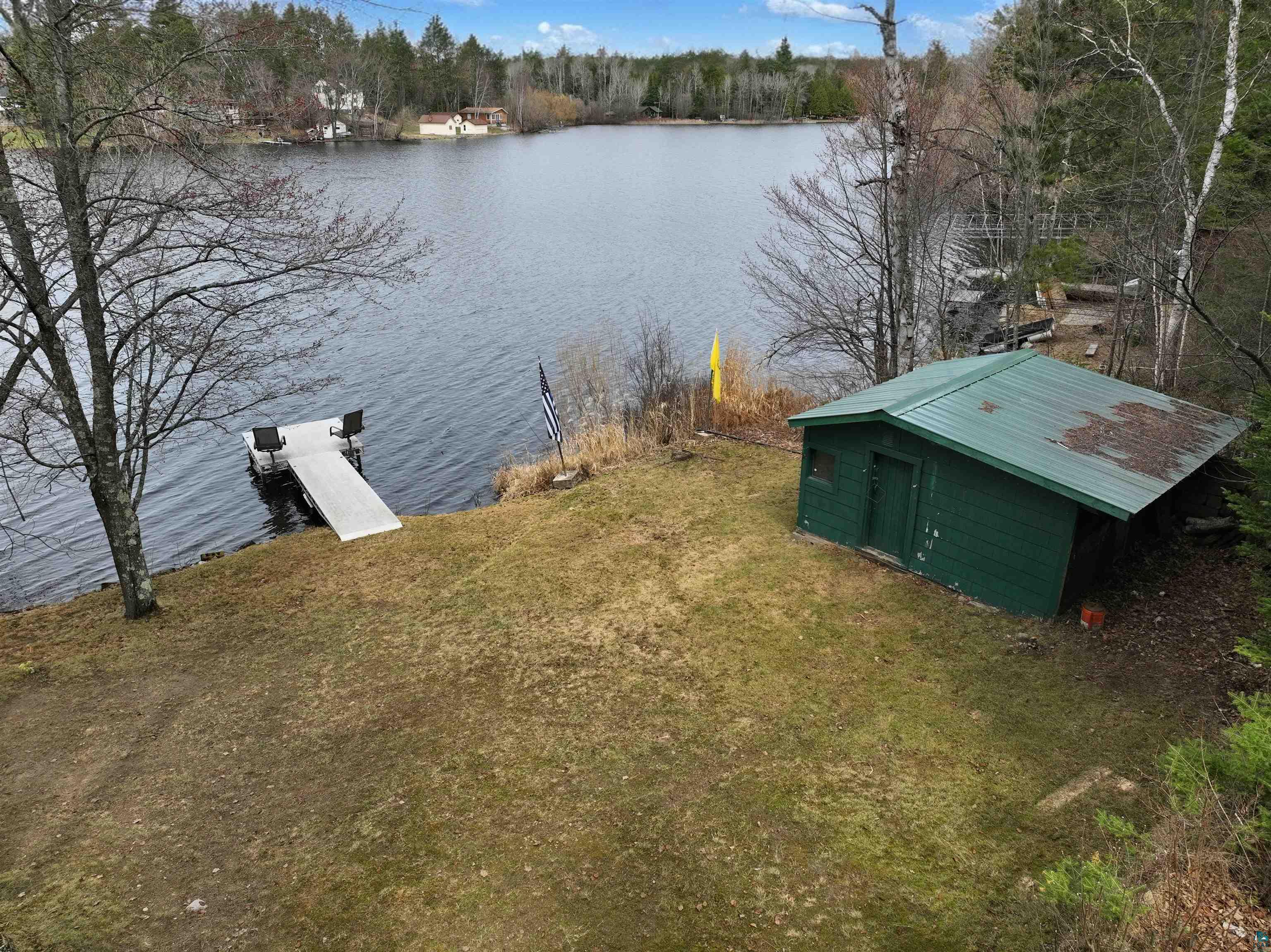 3975 Long Lake Shores Road Eveleth, MN 55734 - Photo 9 of 84 Waterfront property featuring a private dock, green storage shed with metal roof, and natural landscaping