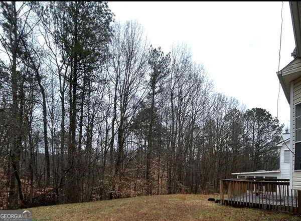 a view of backyard with deck and trees