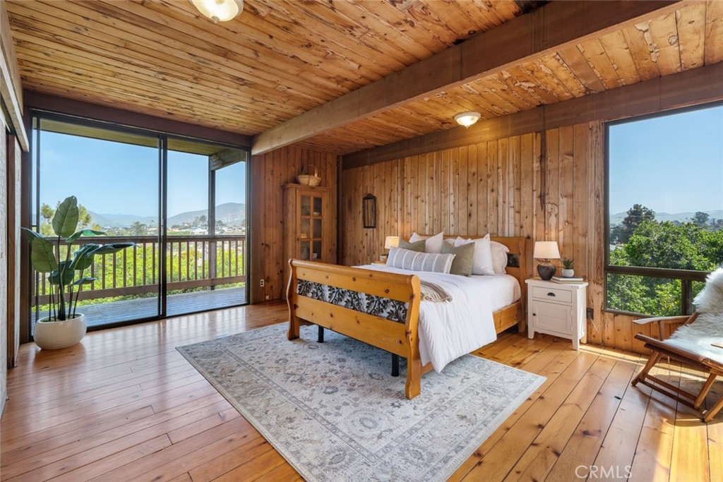 1515 9th Street Los Osos, CA 93402 - Photo 16 of 69 a spacious bedroom with a bed and glass door