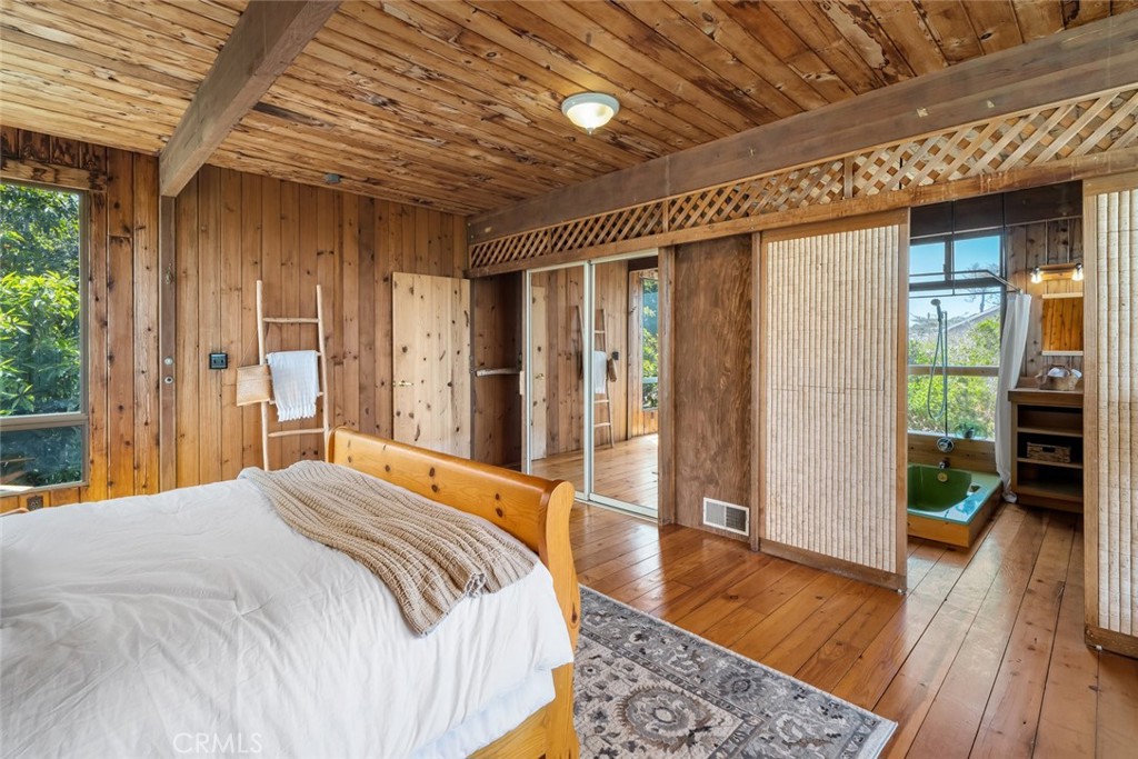 1515 9th Street Los Osos, CA 93402 - Photo 22 of 69 a bedroom with a bed and wooden floor