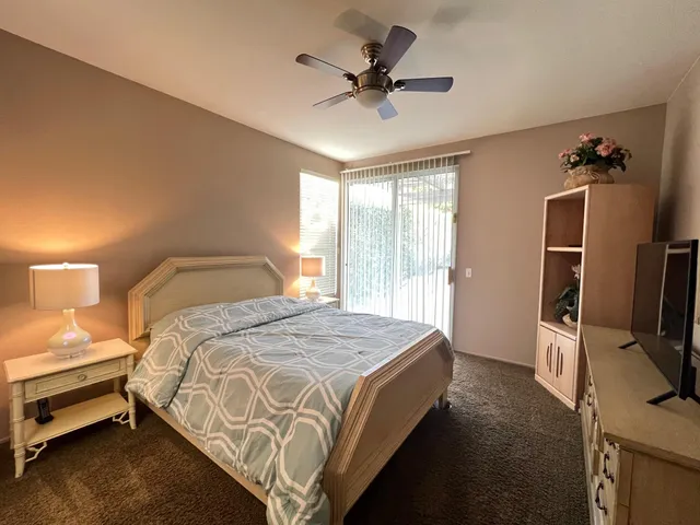 a bedroom with a bed tv and a window