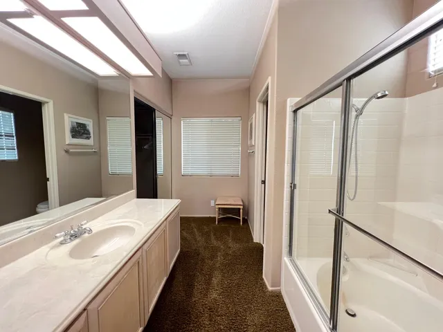 a en suite bathroom with a sink and a large mirror