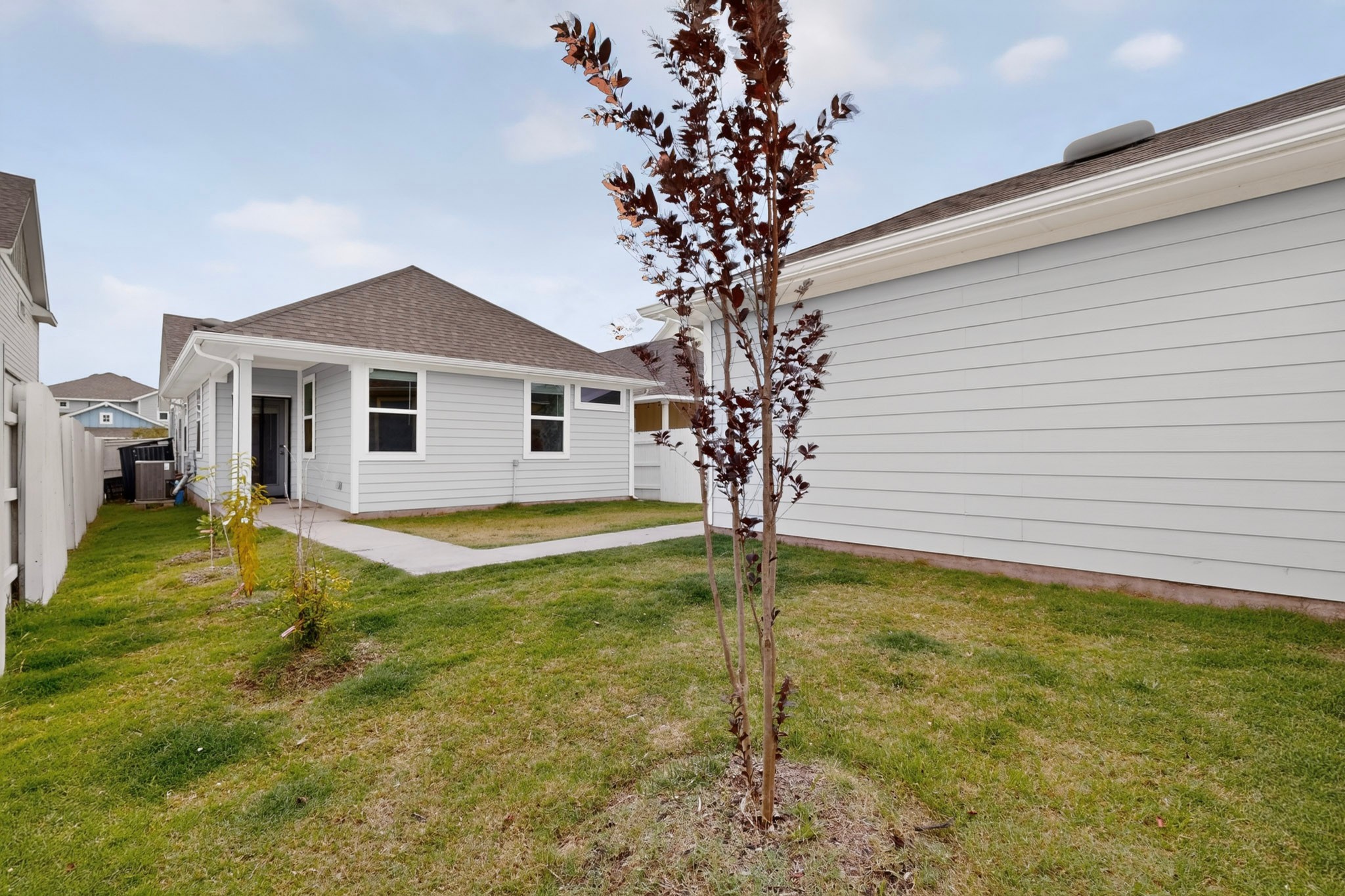 116 Appleberry Lane Elgin, TX 78621 - Photo 32 of 35 A well-maintained lawn embraces this inviting home with its clean siding and convenient pathways.