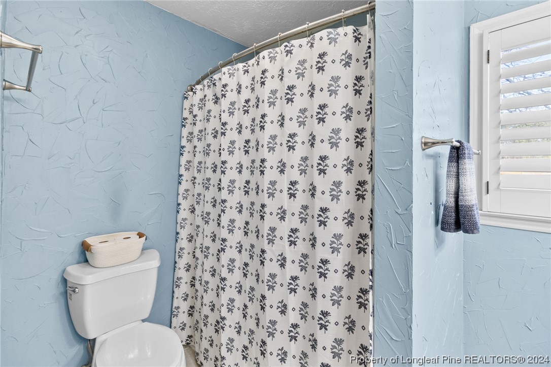 1177 Palestine Road Linden, NC 28356 - Photo 31 of 46 a white toilet sitting next to a shower curtain